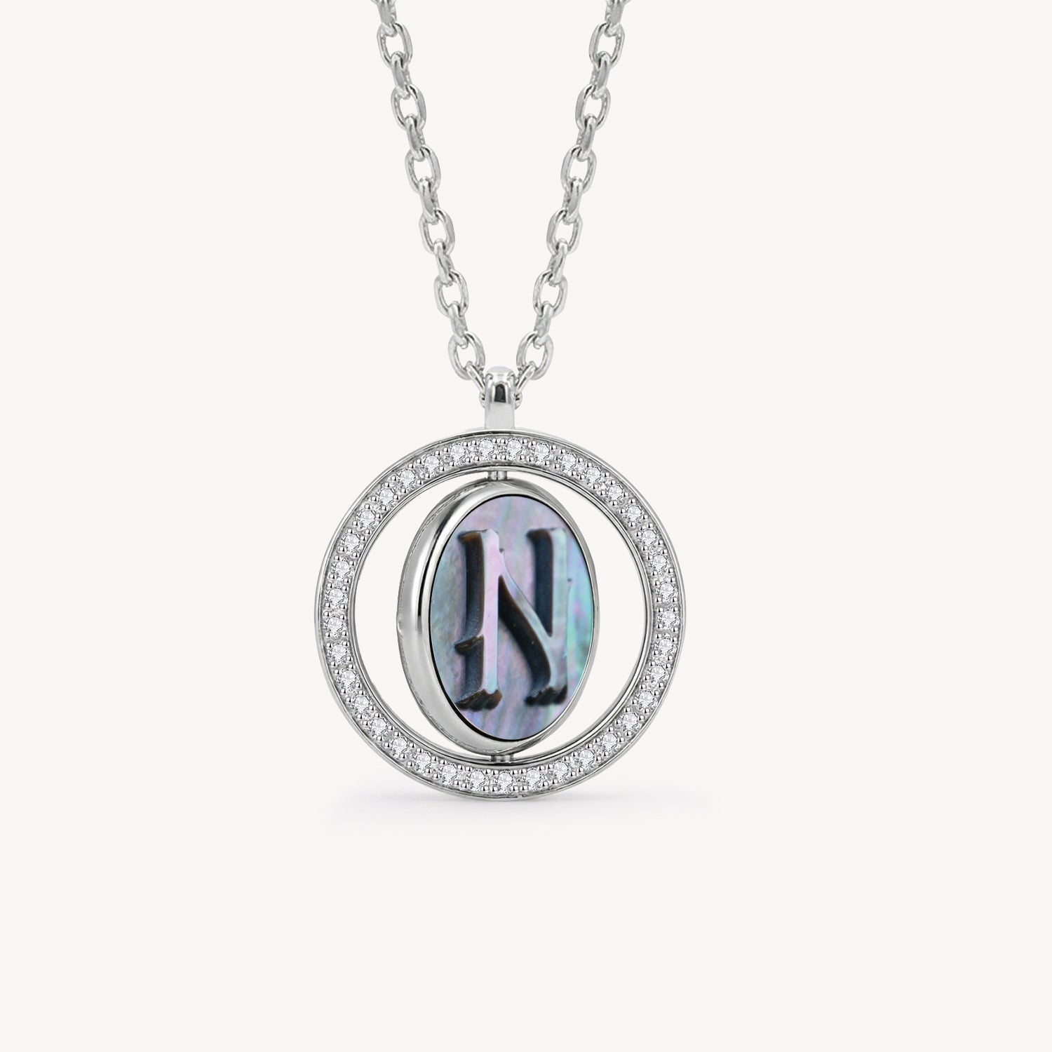 Reversible personalized initial diamond necklace with a black mother-of-pearl background, shown on a 925 sterling silver chain.