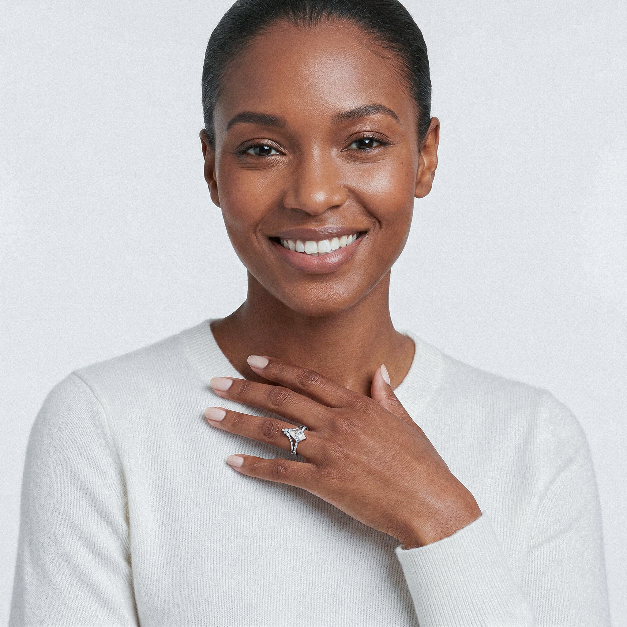 Woman wearing a diamond ring on a plain background