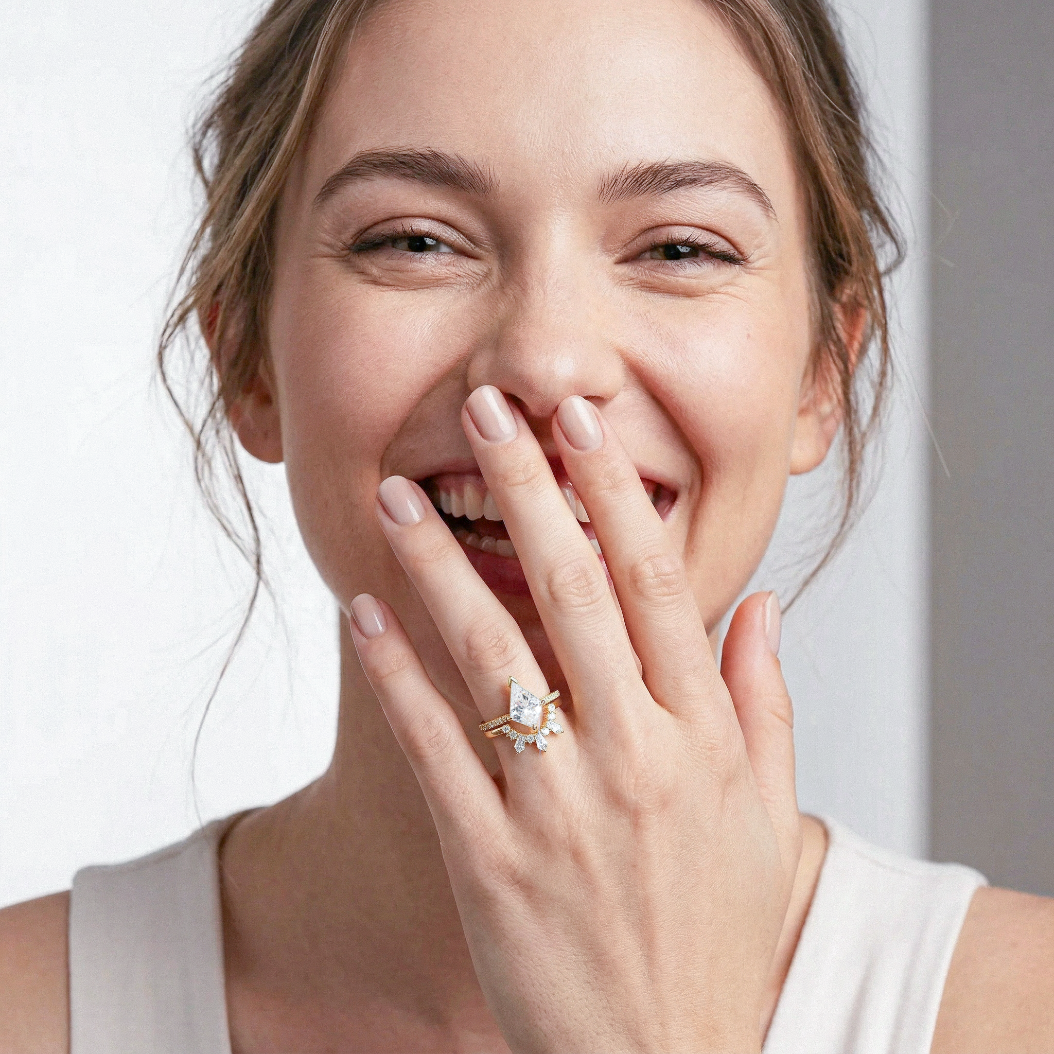 Woman wearing a golden kite diamond ring  set on her finger, smiling.