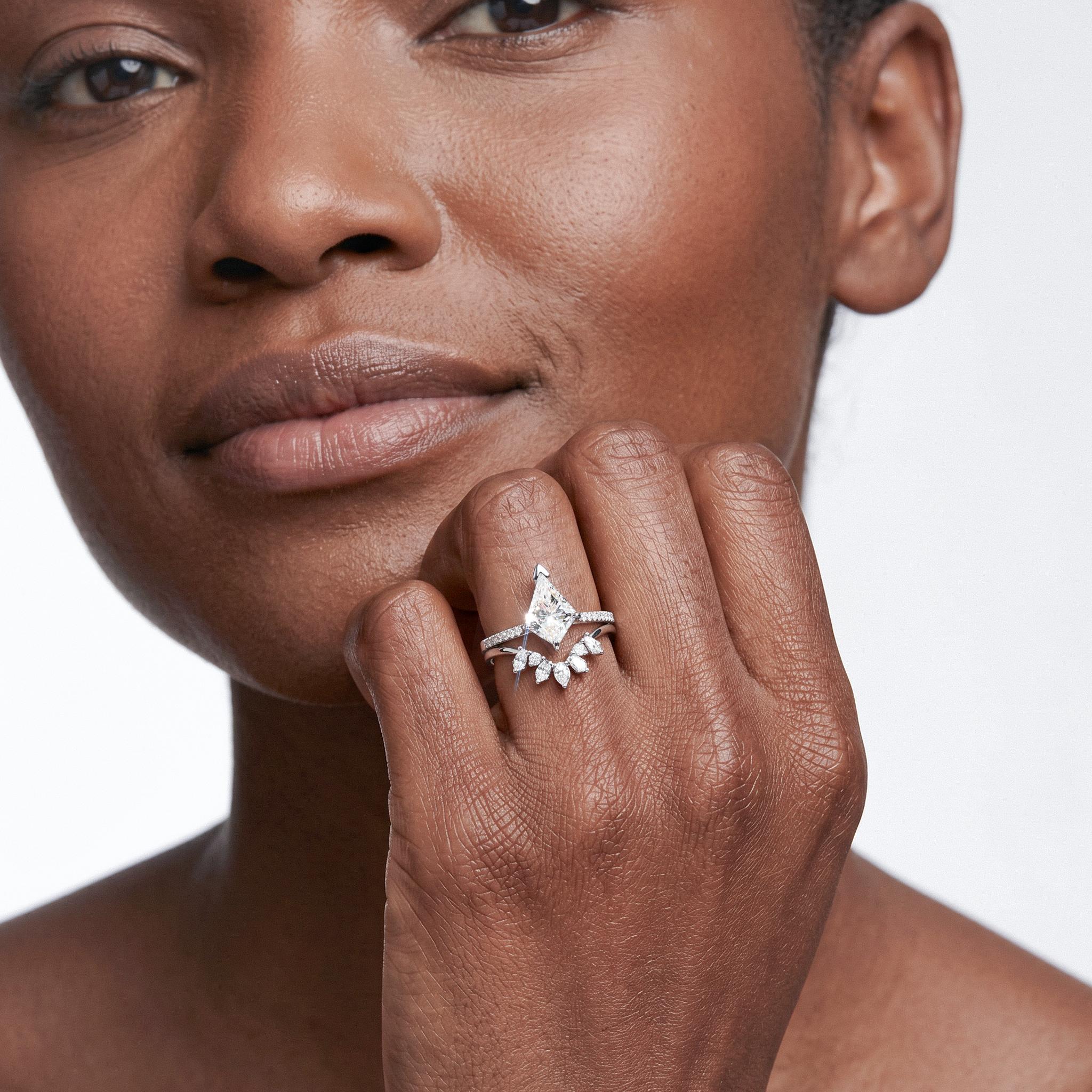 Close-up of a woman's hand wearing a diamond ring on a white background