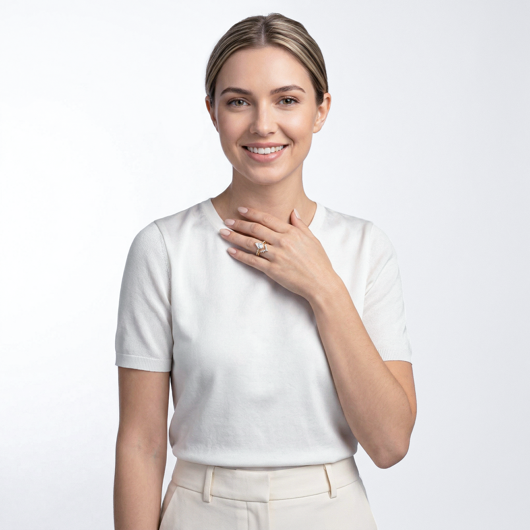 Woman wearing a gold diamond ring set with white shirt  a light gray background