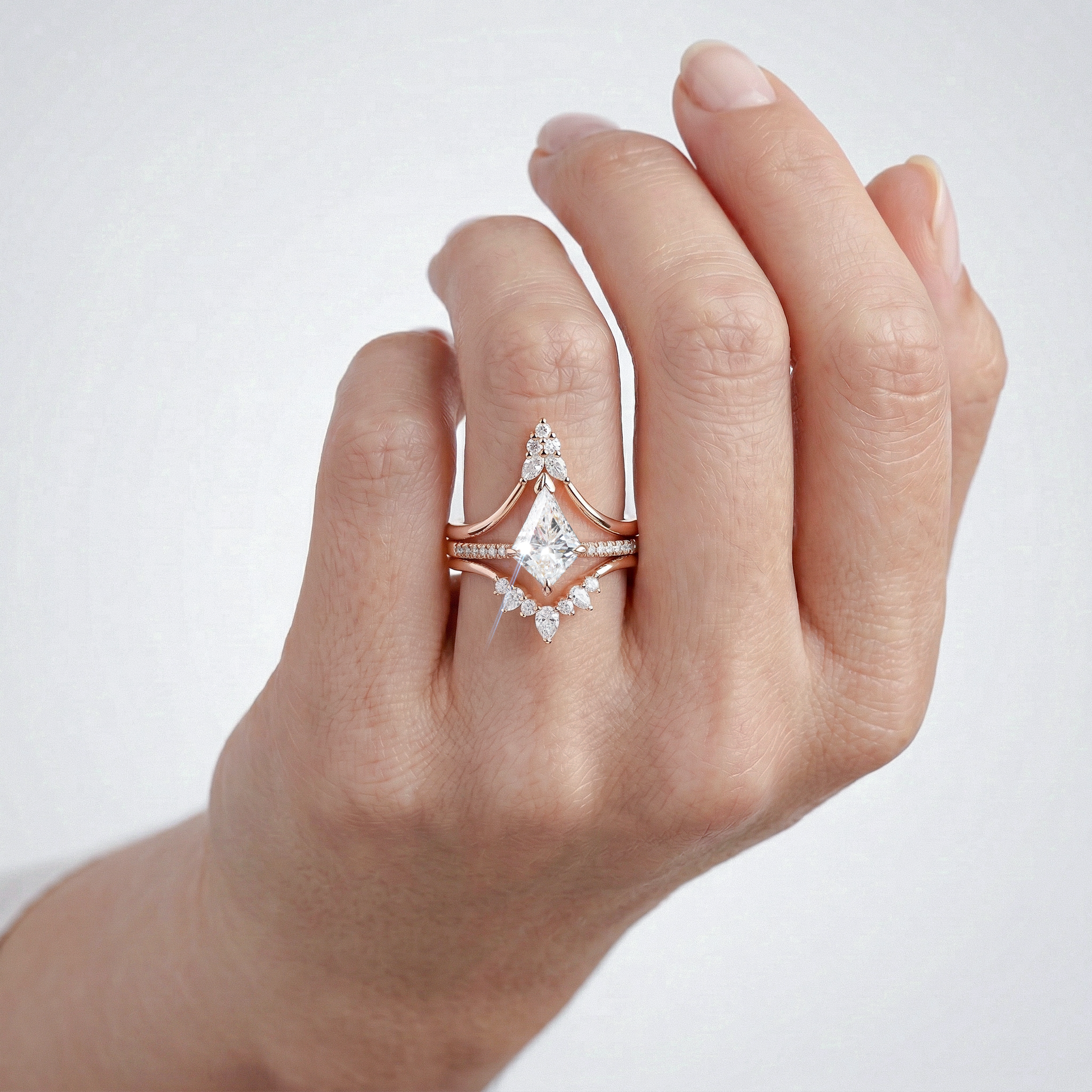 Rose gold ring set with kite shape diamond on a hand against a white background