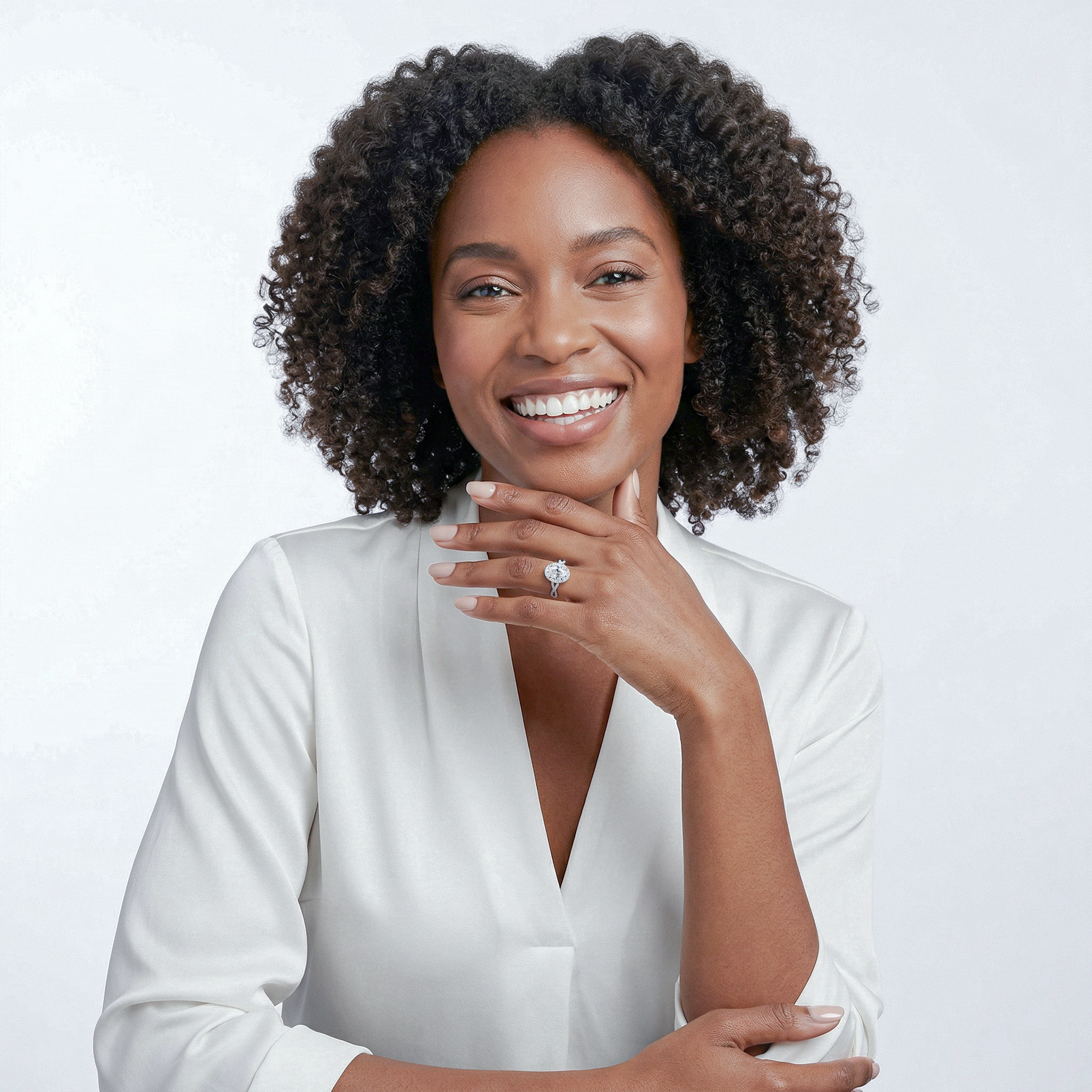 Woman wearing a white gold twisted diamond ring with a plain background