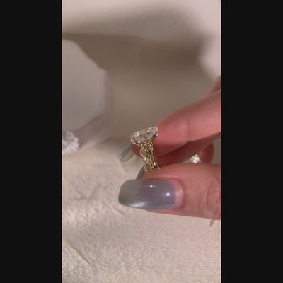 Model wearing an emerald-cut two-ring bridal set with a vintage-style stone band.